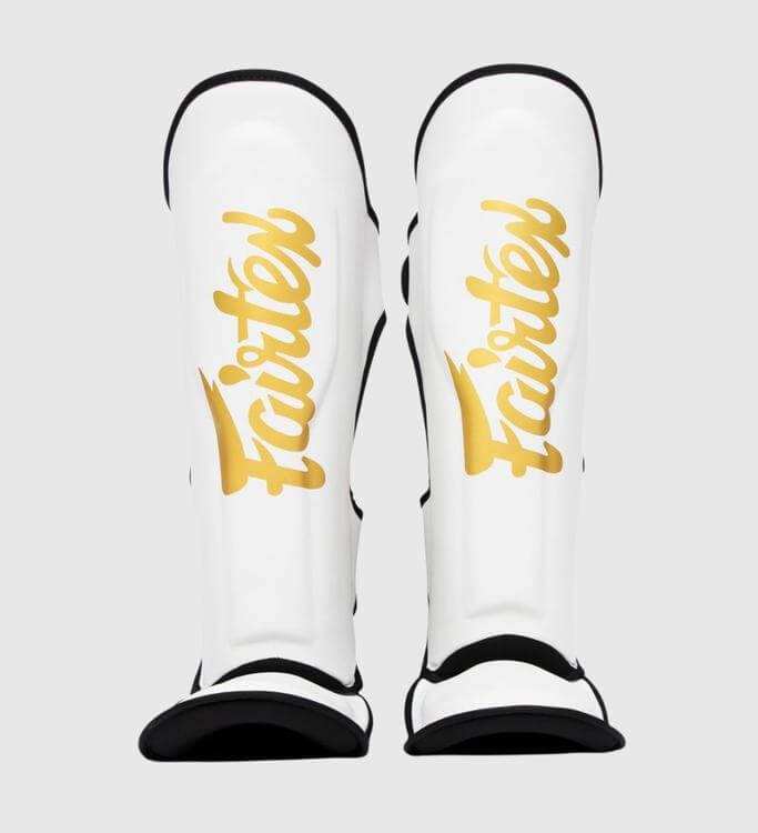 Witte en gouden Fairtex kickboks scheenbeschermers met klittenbandsluiting en foam padding